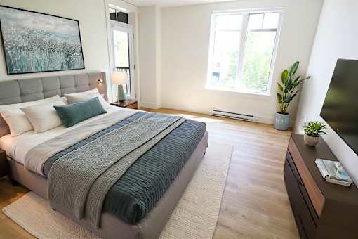 A bedroom with a large bed and a television on a cabinet.
