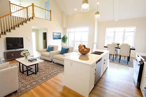 A modern open plan living and kitchen area with a staircase.