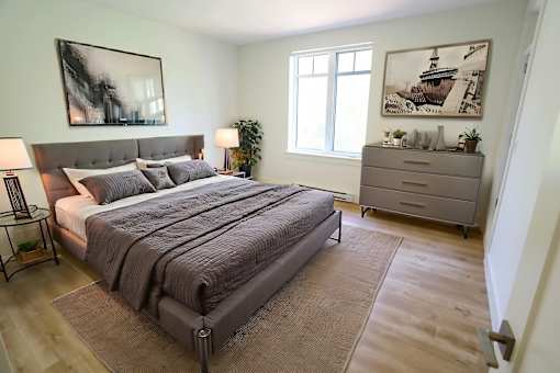 A bedroom with a large bed and a dresser.