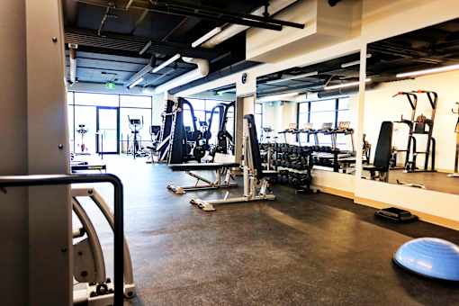 A gym with a variety of equipment including a leg press machine.