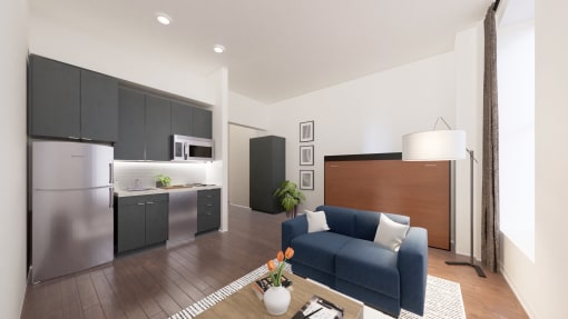 a living room with a blue couch and a kitchen with stainless steel appliances
