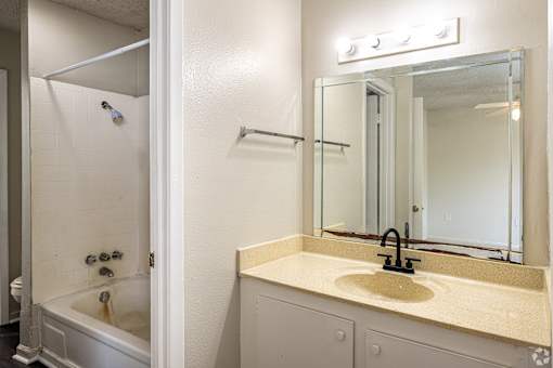 A bathroom with a white tub and sink.