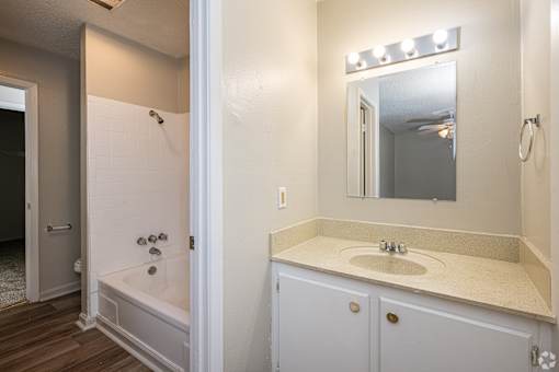 A bathroom with a white tub and sink.