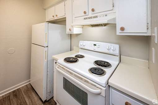 A white stove and refrigerator in a small kitchen.