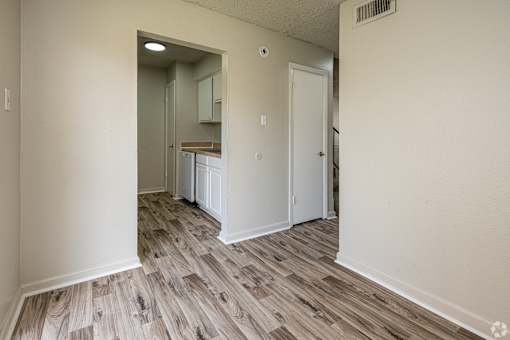 A room with a white door and a wooden floor.