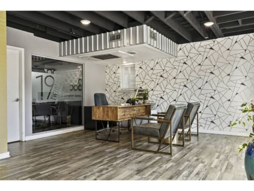 a conference room with a desk and chairs and a white wall