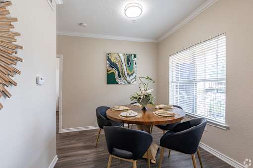 A dining room with a round table set for four.