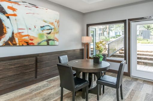 A dining room with a round table and chairs.