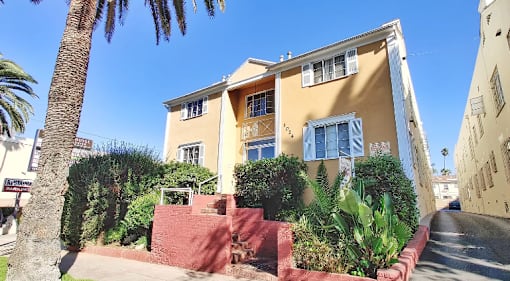 a house with a staircase and a palm tree in front of it