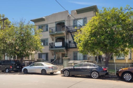 an apartment building with cars parked in front of it
