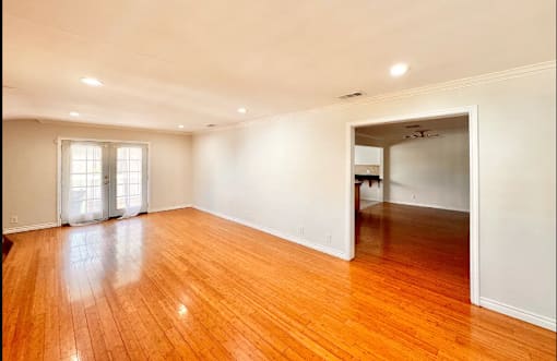A room with wooden floors and a sliding glass door.