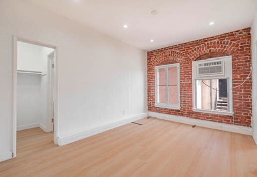 A room with a brick wall and wooden flooring.