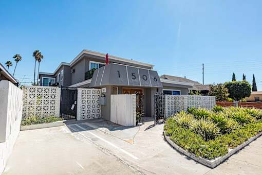 the front of a house with a driveway and a gate