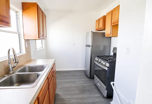 A kitchen with a stainless steel refrigerator and a stainless steel sink.