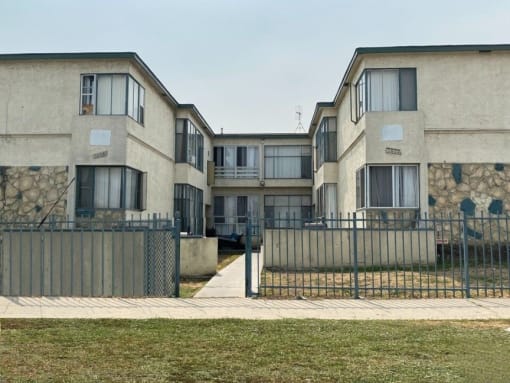 a row of houses with a sidewalk and a fence