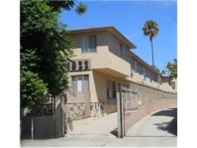 a building with a fence and a palm tree
