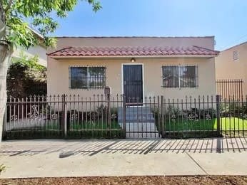 a house with a fence and a gate in front of it