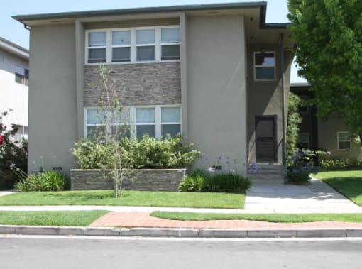 the front of a house with a sidewalk and grass