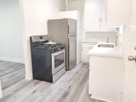 an empty kitchen with a stove and a refrigerator
