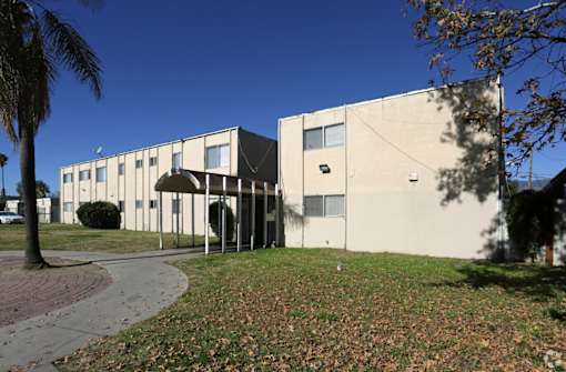 the exterior of an office building with a sidewalk and grass