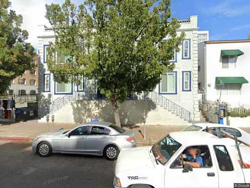 two cars parked on a street in front of houses