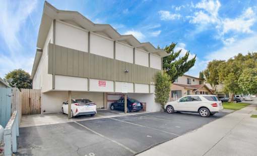 a large white building with cars parked in front of it