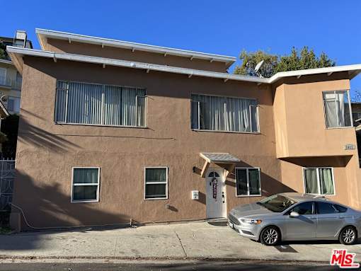 an apartment building with a car parked in front of it
