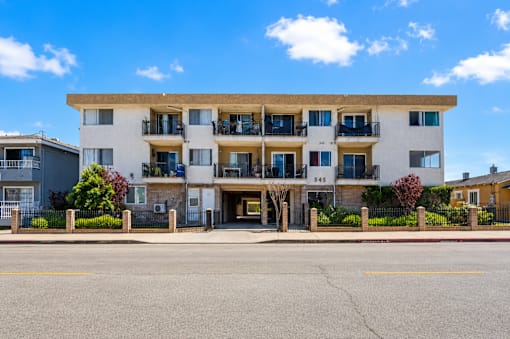 A large white building with balconies and the number 545 on it.