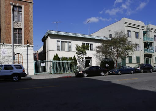 a white building on a city street with cars
