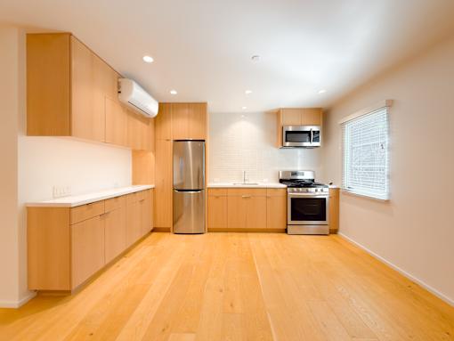 A kitchen with wooden floors and cabinets.