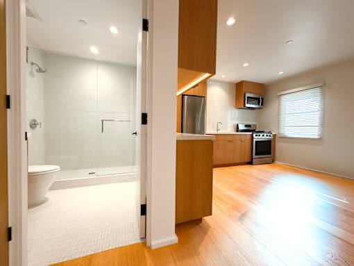 A modern bathroom with a walk-in shower and a wooden cabinet.