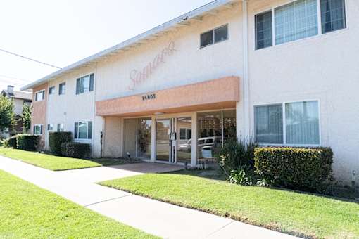 A white building with a red sign that says "Sunrise" on it.