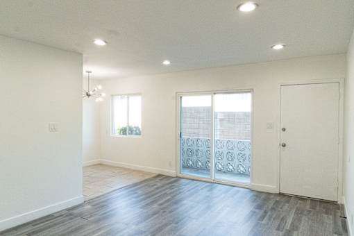 A room with a wooden floor and a white door.
