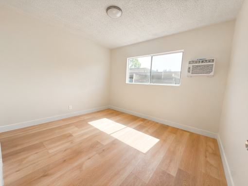 A room with wooden flooring and a window.