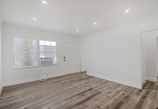 A room with wooden flooring and a window.