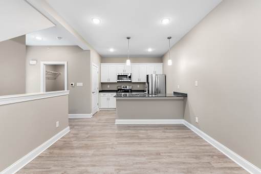 an empty kitchen with white cabinets and stainless steel appliances