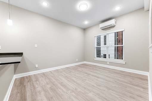 an empty living room with white walls and wood flooring