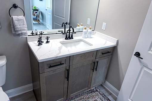 A bathroom with a white sink and a towel rack.