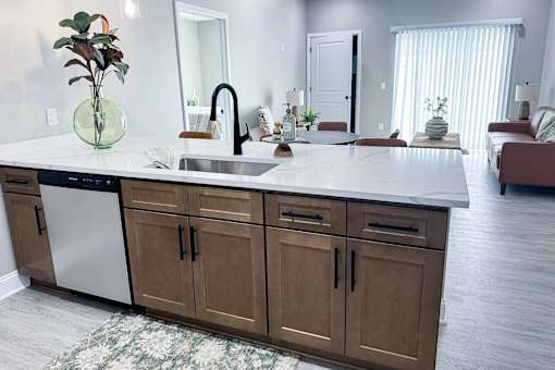 A kitchen with a white countertop and brown cabinets.