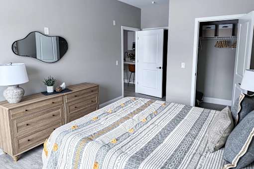 A bedroom with a bed, dresser, and mirror.