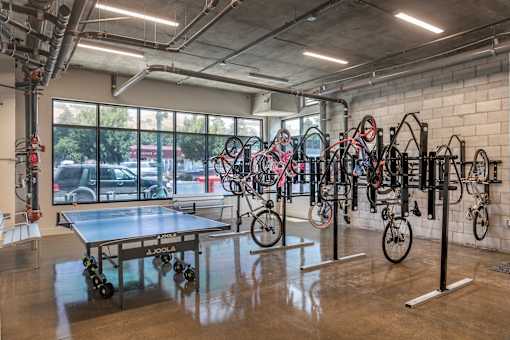 A room with a table, chairs, and bicycles.