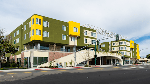 a yellow and green building on the corner of a street