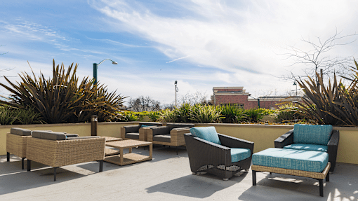 a patio with chairs and a table on a roof