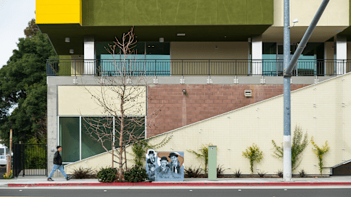 a man walking past a building with a mural on the side of it