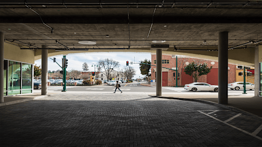 a person crossing the street in an empty parking garage