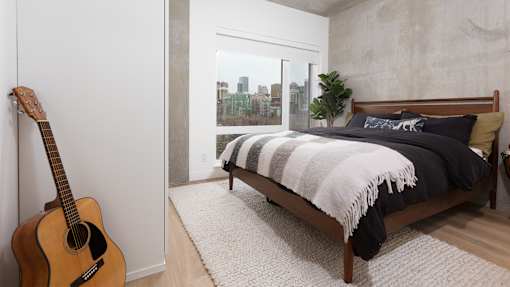 a bedroom with a bed and a guitar in it