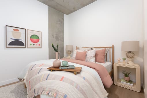 a bedroom with a bed and two paintings on the wall