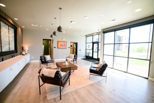 a large living room with large windows and a table and chairs