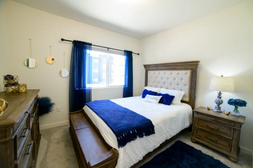 a bedroom with a bed and blue and white bedding and a window