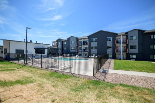 an apartment building with a swimming pool and a fence
